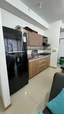 a kitchen with a black refrigerator and wooden cabinets at Apartamento el Paraíso T3-302 in San Jerónimo