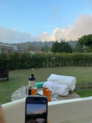 a table with a bottle of wine and a cell phone at Nativo House in Guarne