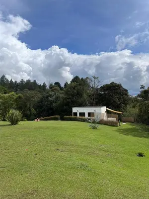 a large grassy field with a building in the background at Nativo House in Guarne