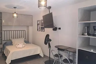 a small bedroom with a bed and a table and a tableablish at Exclusive Studio in the Best Laureles Area in Medellín