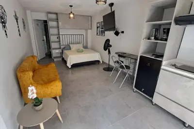 a small living room with a bed and a kitchen at Exclusive Studio in the Best Laureles Area in Medellín