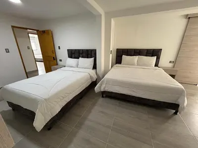 two beds sitting next to each other in a bedroom at Casa Vernazza in Manizales