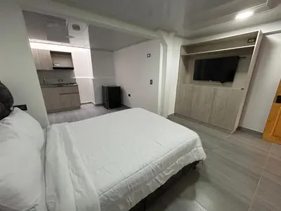 a bedroom with a bed and a flat screen tv at Casa Vernazza in Manizales
