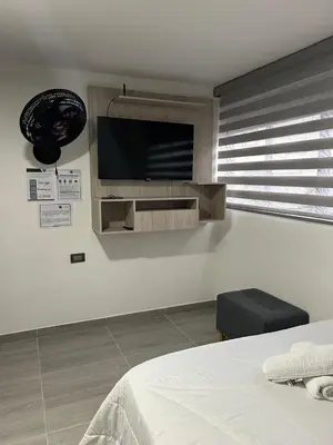 a bedroom with a bed and a flat screen tv on the wall at Casa Vernazza in Manizales
