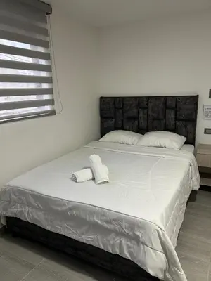 a large white bed with two white towels on it at Casa Vernazza in Manizales