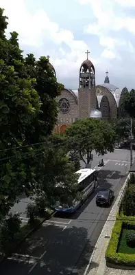 a bus parked in front of a building with a church at usoinmobiliario in Medellín