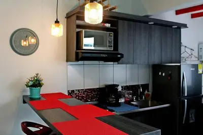 a kitchen with a red counter top and a microwave at APARTAMENTO PRIVADO Y TRANQUILO EN MANILA. in Medellín