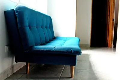 a blue leather chair sitting in a room at APARTAMENTO PRIVADO Y TRANQUILO EN MANILA. in Medellín