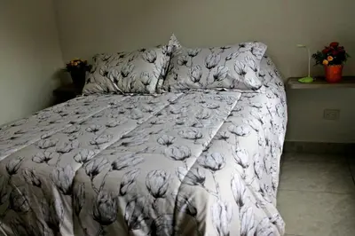 a bed with a white comforter and pillows at APARTAMENTO PRIVADO Y TRANQUILO EN MANILA. in Medellín