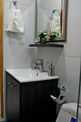 a bathroom with a sink and a mirror and a toilet at APARTAMENTO PRIVADO Y TRANQUILO EN MANILA. in Medellín