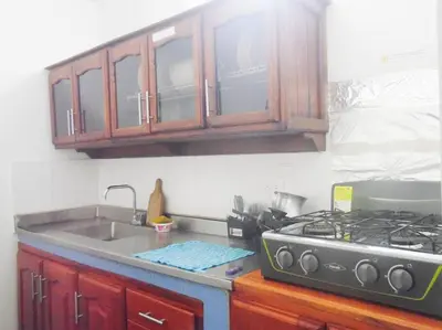 a kitchen counter with a stove and a sink at Fantástico y cómodo a 1Km de la hacienda Nápoles in Doradal