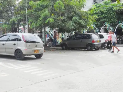 two cars parked in a parking lot with people walking at Fantástico y cómodo a 1Km de la hacienda Nápoles in Doradal