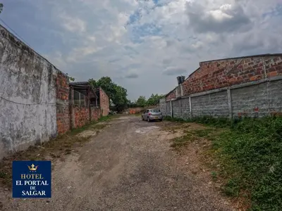 a car parked on a dirt road between two brick buildings at Hotel El Portal de Salgar in Puerto Salgar