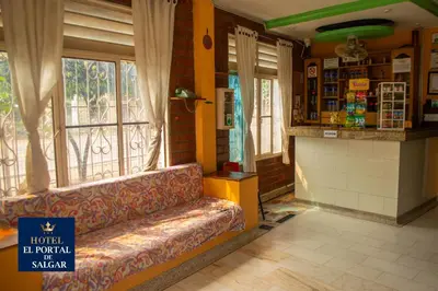 a living room with a couch in a room with windows at Hotel El Portal de Salgar in Puerto Salgar