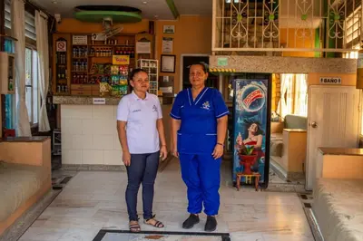 a man and a woman standing in front of a store at Hotel El Portal de Salgar in Puerto Salgar