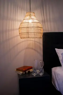 a lamp and a book on a table next to a bed at Monarch Campestre- Rionegro in Rionegro