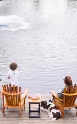 two people sitting in chairs next to a body of water at Monarch Campestre- Rionegro in Rionegro