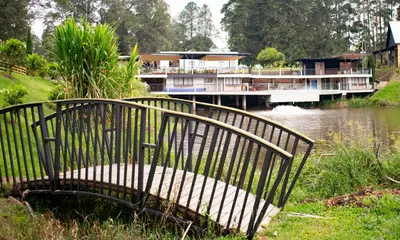 a bench sitting next to a river with a boat at Monarch Campestre- Rionegro in Rionegro