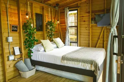 a bedroom with a bed in a room with wooden walls at Cabaña Glamping San Carlos Antioquía Pun chinaw Ecocabañas in San Carlos