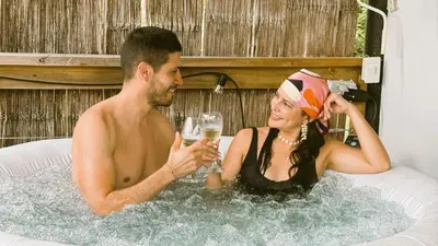 a man and woman sitting in a bath tub with champagne at Cabaña Glamping San Carlos Antioquía Pun chinaw Ecocabañas in San Carlos