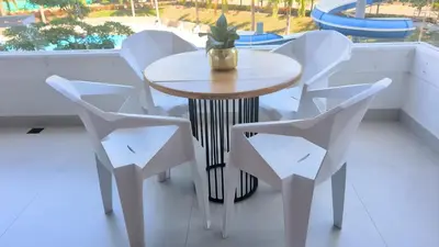 a table and chairs with a plant on a balcony at santa fe de Antioquia pueblo apto in Santa Fe de Antioquia