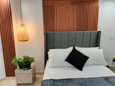 a bedroom with a bed with a black headboard and white pillows at Exclusivo Apto lujoso central, sereno y cómodo 302 in Medellín