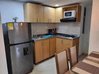 a kitchen with wooden cabinets and a stainless steel refrigerator at Exclusivo Apto lujoso central, sereno y cómodo 302 in Medellín