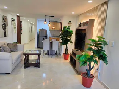 a living room with a couch and two potted plants at Exclusivo Apto lujoso central, sereno y cómodo 302 in Medellín