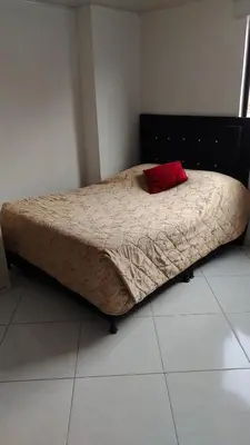 a bed in a bedroom with a red pillow on it at HABITACIÓN PRIVADA tranquila y confortable in Bello