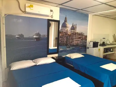 two beds in a room with a painting on the wall at Apartamento Encanto in Puerto Triunfo