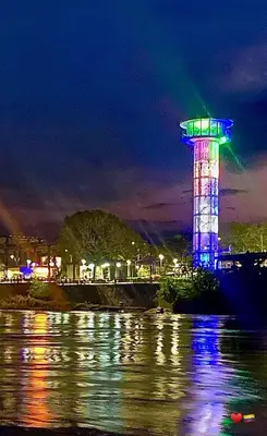 a lit up tower next to the water at night at Apartamento Encanto in Puerto Triunfo