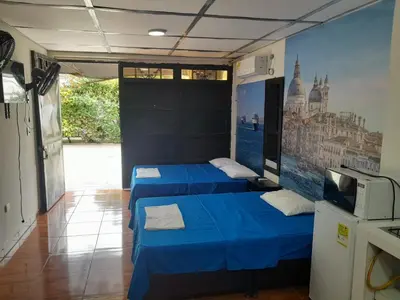 a room with three beds with a tv and a mural at Apartamento Encanto in Puerto Triunfo