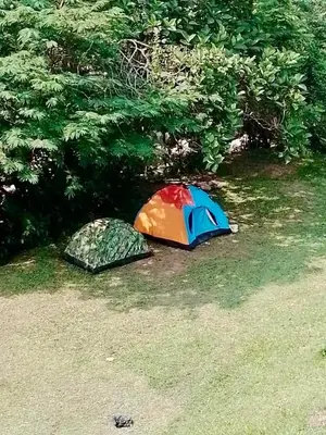 two tents sitting on the ground in the grass at La Clarita in San Rafael