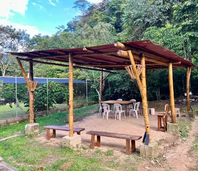 a wooden pavilion with a table and benches in a yard at La Clarita in San Rafael