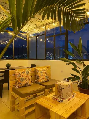 a room with a bench and a table and windows at Suite con hamaca y baño privado. in Manizales