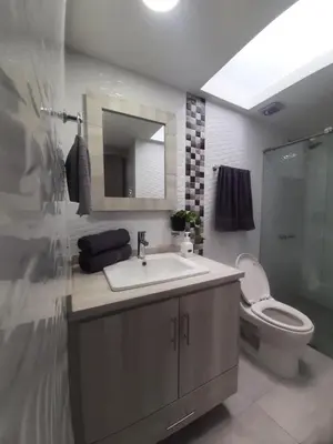 a bathroom with a sink and a toilet and a mirror at Suite con hamaca y baño privado. in Manizales