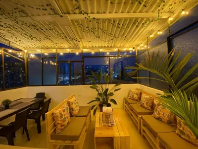 a living room with a couch and a table and chairs at Suite con hamaca y baño privado. in Manizales