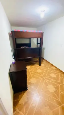 a room with a chair and a table in a room at Casa Confortable 2 habitaciones, pateo , parqueadero in Medellín