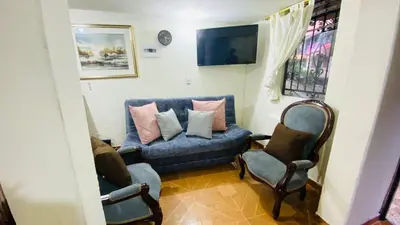 a living room with a blue couch and two chairs at Casa Confortable 2 habitaciones, pateo , parqueadero in Medellín