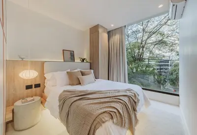 a bedroom with a bed and a large window at Primavera Building in Medellín