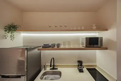 a kitchen with a sink and glasses on a shelf at Primavera Building in Medellín