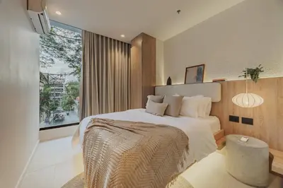 a bedroom with a large bed and a large window at Primavera Building in Medellín