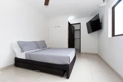 a bedroom with a bed and a flat screen tv at ¡Apartamento HOME LAURELES excelente ubicación! in Medellín