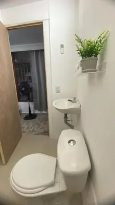 a bathroom with a white toilet and a sink at APARTAHOTEL ESTADIO GOLD in Medellín