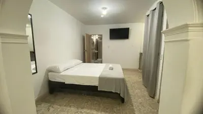 a small bedroom with a bed and a bathroom at APARTAHOTEL ESTADIO GOLD in Medellín
