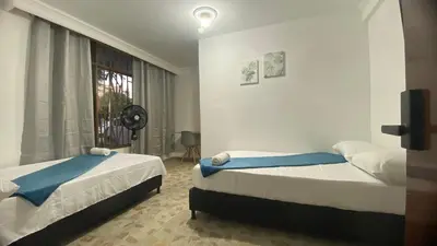 a bedroom with two beds and a window at APARTAHOTEL ESTADIO GOLD in Medellín
