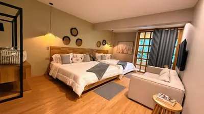 a bedroom with a large bed and a couch at M de oro Apartamentos Muuk boutique POBLADO in Medellín