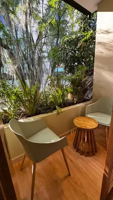 a room with a chair and a window with plants at M de oro Apartamentos Muuk boutique POBLADO in Medellín