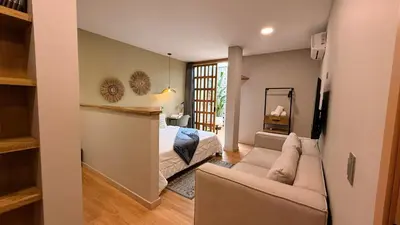 a living room with a bed and a couch at M de oro Apartamentos Muuk boutique POBLADO in Medellín