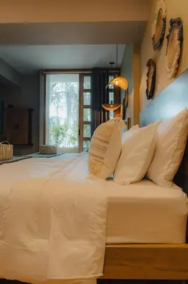 a bedroom with a large bed with white pillows at M de oro Apartamentos Muuk boutique POBLADO in Medellín